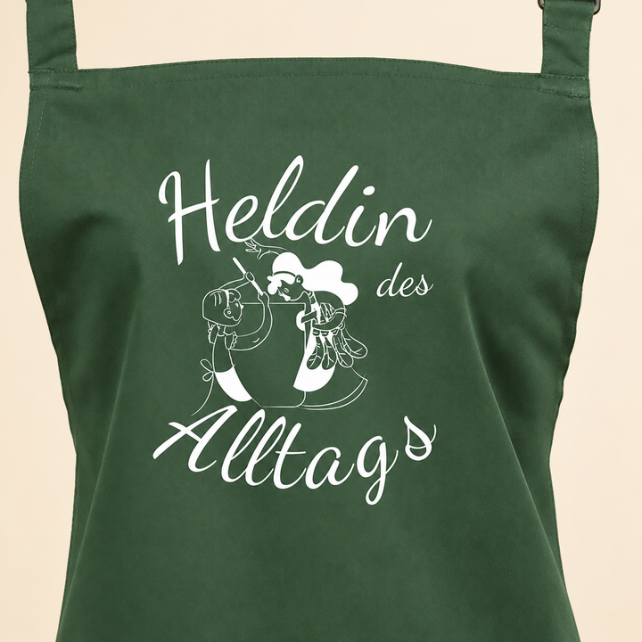 Kochschürze „Heldin des Alltags“ – Produkt auf cremefarbenem Hintergrund