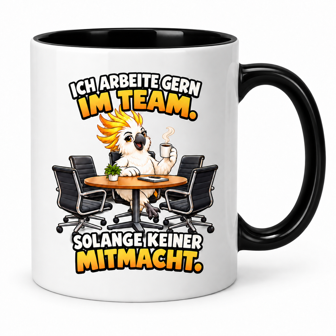 Kakadu-Tasse in Schwarz – Ich arbeite gern im Team. Solange keiner mitmacht.