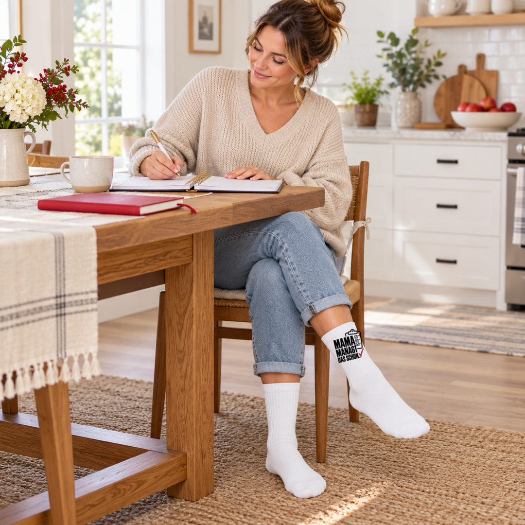 Weiße Mama-Socken beim Planen am Küchentisch – Geschenkidee für Mütter