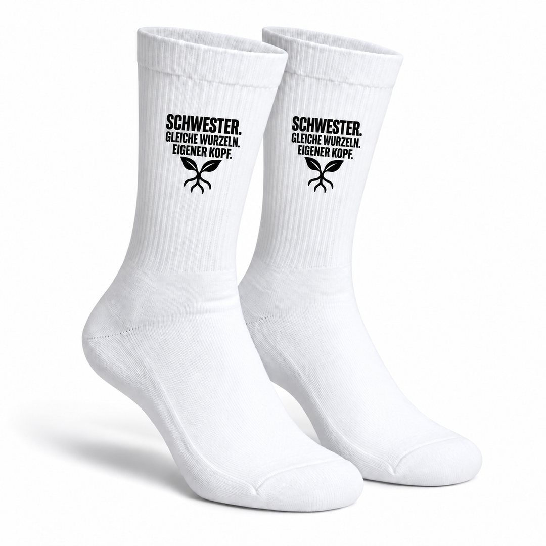 Weiße Schwester-Socken als Paar mit schwarzem Aufdruck Gleiche Wurzeln. Eigener Kopf. und Blätter-Wurzelmotiv