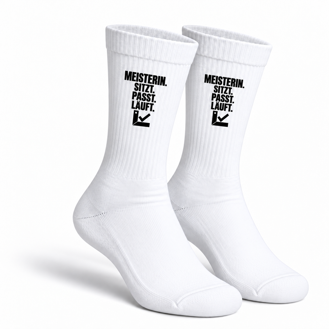 Weiße Handwerkerin-Socken als Paar mit schwarzem Aufdruck Meisterin. Sitzt. Passt. Läuft.