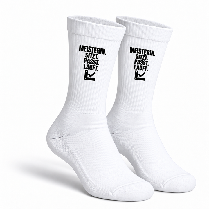 Weiße Handwerkerin-Socken als Paar mit schwarzem Aufdruck Meisterin. Sitzt. Passt. Läuft.
