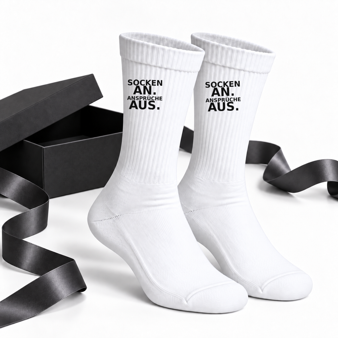 Lustige Socken als Geschenkidee neben schwarzer Geschenkbox