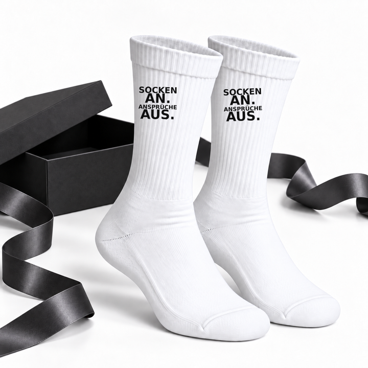 Lustige Socken als Geschenkidee neben schwarzer Geschenkbox