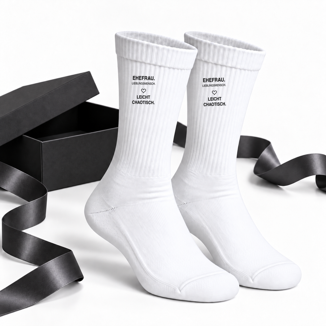 Ehefrau-Socken als Geschenkidee neben einer schwarzen Geschenkbox