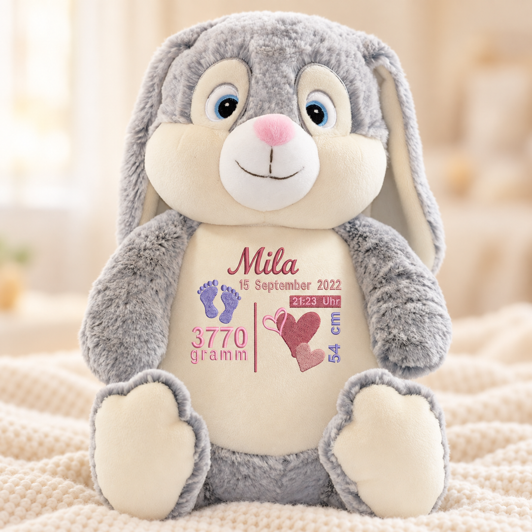 Grauer Kuschelhase Baby Bunny mit Beispielpersonalisierung Mila auf einer cremefarbenen Decke