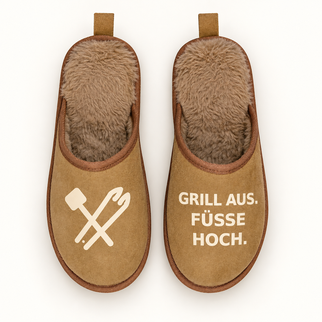 Braune Terra Hausschuhe direkt von oben mit Grillbesteck-Motiv und Schriftzug Grill aus. Füße hoch.