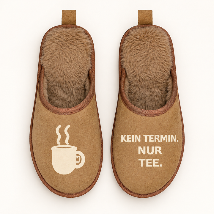 Braune Terra Hausschuhe direkt von oben mit Teetassen-Motiv und Schriftzug Kein Termin. Nur Tee.