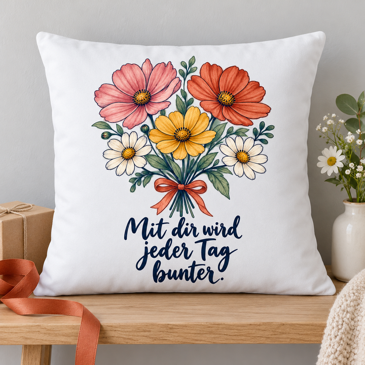 Blumenkissen „Mit dir wird jeder Tag bunter“ neben einer Geschenkbox