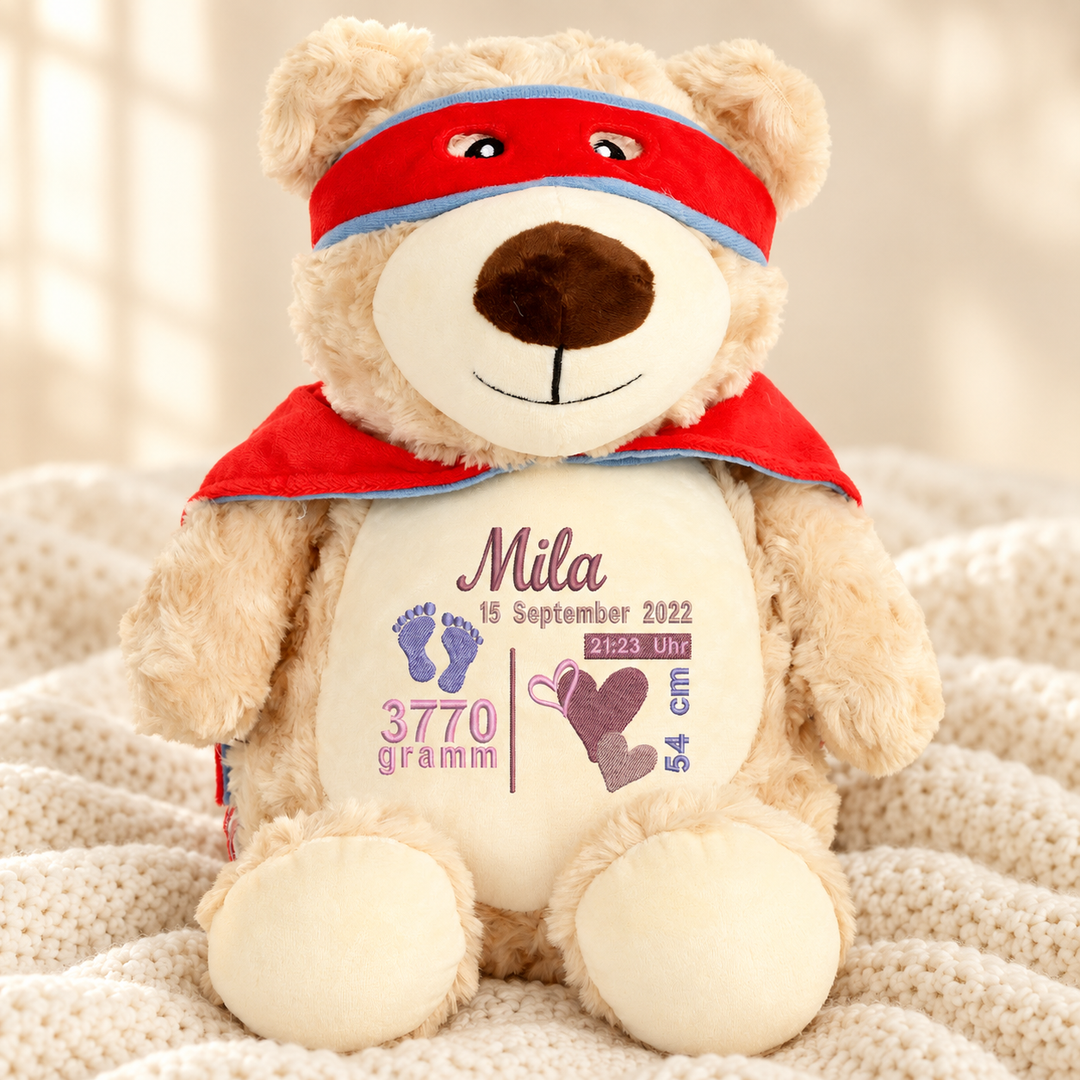 Personalisiertes Kuscheltier Bär mit Name – Beispiel Mila auf cremefarbener Decke