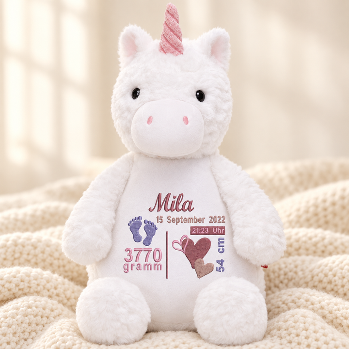Personalisiertes Kuscheltier Einhorn mit Name – Beispiel Mila auf cremefarbener Decke