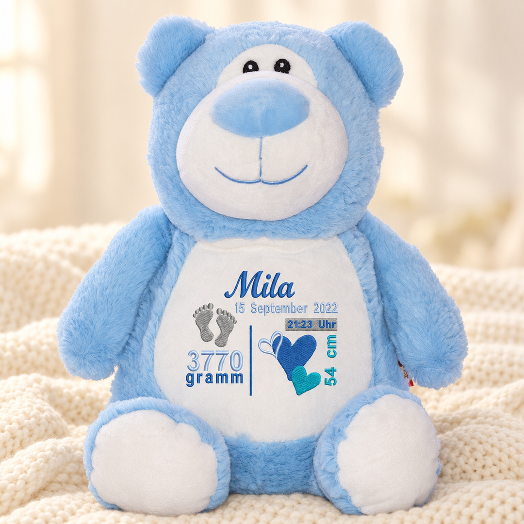 Personalisiertes Kuscheltier Bär Blau mit Name – Beispiel Mila auf cremefarbener Decke