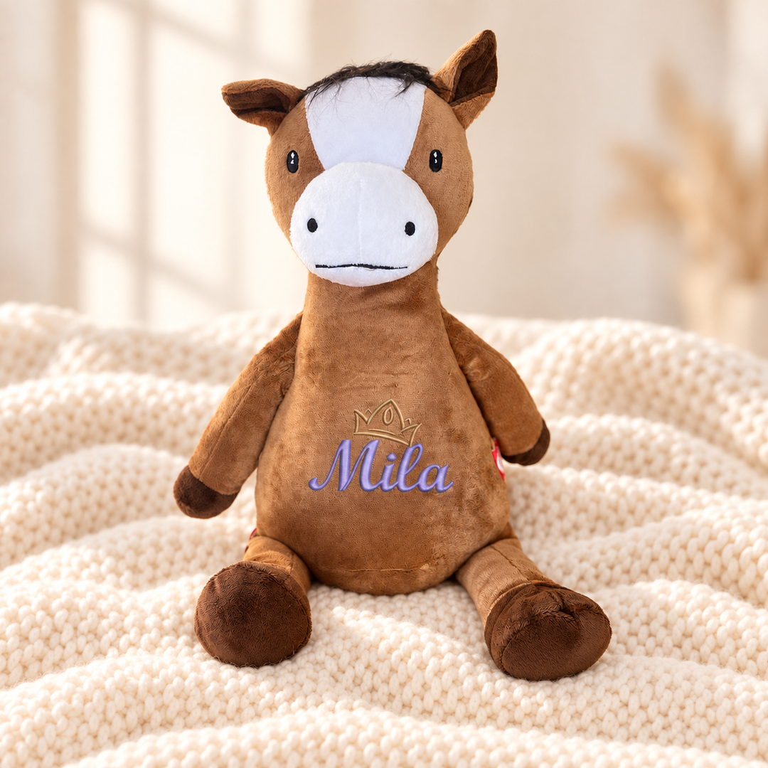 Personalisiertes Kuscheltier Pferd mit Name & Krone – Beispiel Mila auf cremefarbener Decke