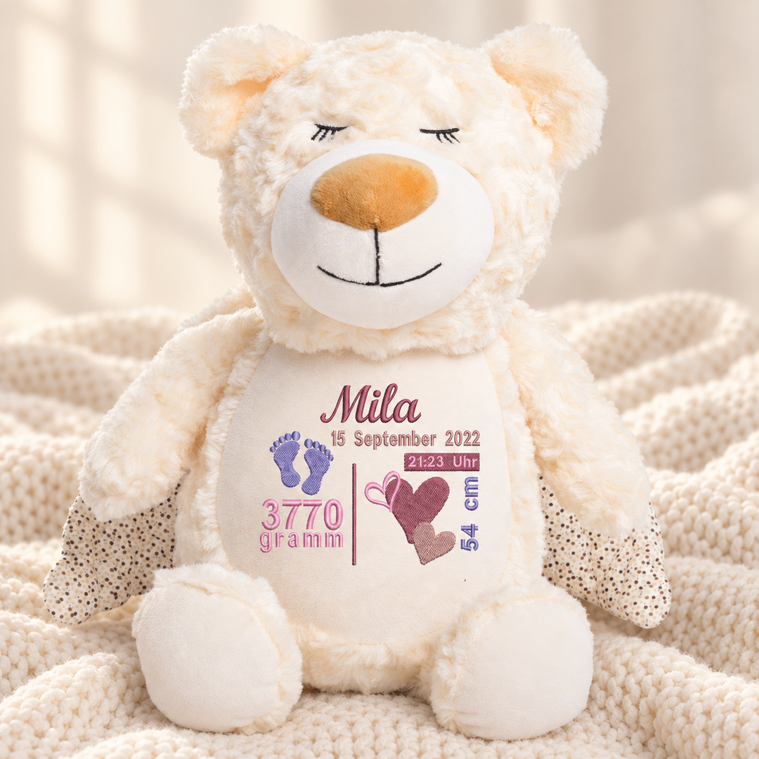 Personalisiertes Kuscheltier Guardian Bear mit Name & Geburtsdaten – Beispiel Mila auf cremefarbener Decke