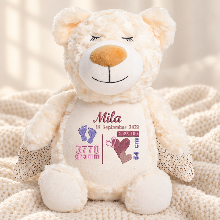 Personalisiertes Kuscheltier Guardian Bear mit Name &amp; Geburtsdaten – Beispiel Mila auf cremefarbener Decke