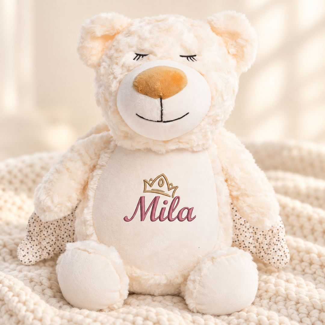 Personalisiertes Kuscheltier Guardian Bear mit Name – Beispiel Mila auf cremefarbener Decke