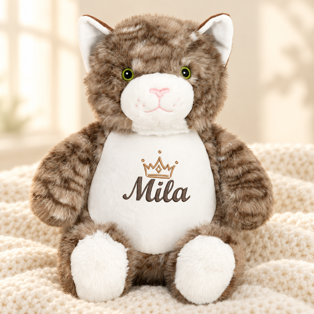 Personalisiertes Kuscheltier Cat mit Name – Beispiel Mila auf cremefarbener Decke