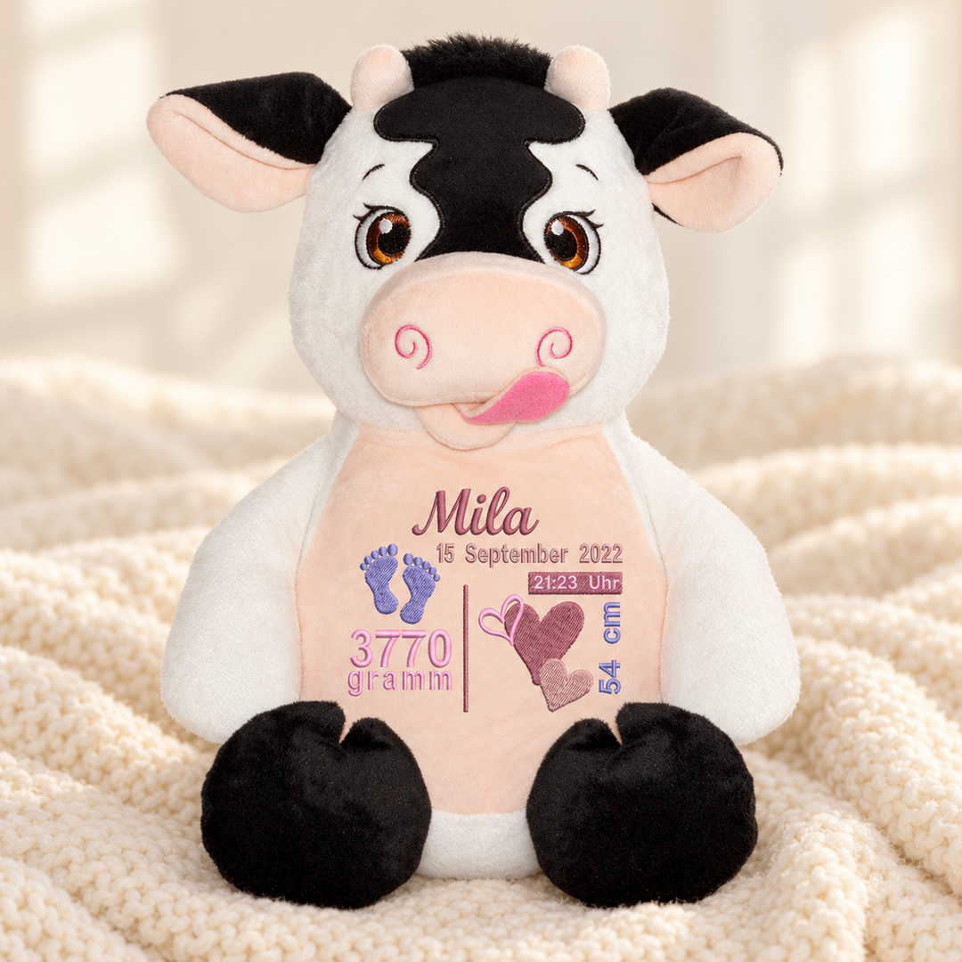 Personalisiertes Kuscheltier Baby Cow mit Name & Geburtsdaten – Beispiel Mila auf cremefarbener Decke