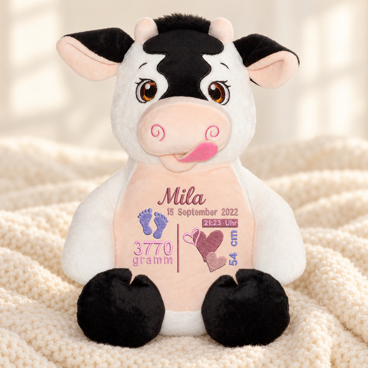 Personalisiertes Kuscheltier Baby Cow mit Name &amp; Geburtsdaten – Beispiel Mila auf cremefarbener Decke