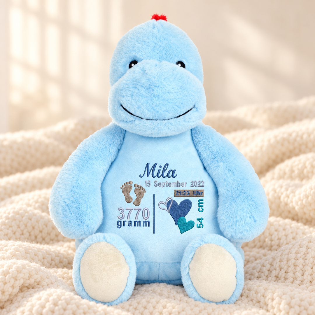 Personalisiertes Kuscheltier Baby Dinosaurier mit Name & Geburtsdaten – Beispiel Mila auf cremefarbener Decke