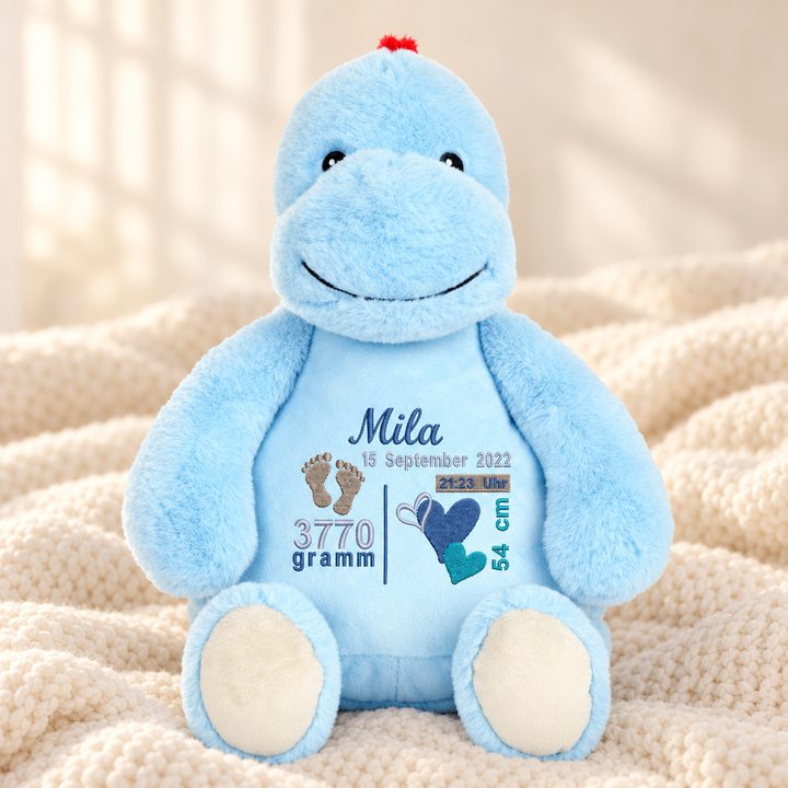 Personalisiertes Kuscheltier Baby Dinosaurier mit Name &amp; Geburtsdaten – Beispiel Mila auf cremefarbener Decke
