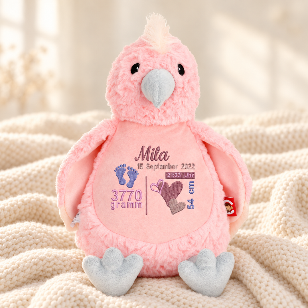 Personalisiertes Kuscheltier Baby Cockatoo mit Name & Geburtsdaten – Beispiel Mila auf cremefarbener Decke