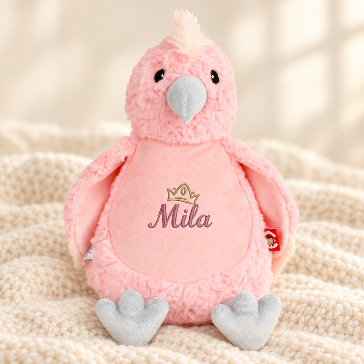 Personalisiertes Kuscheltier Baby Cockatoo mit Name – Beispiel Mila auf cremefarbener Decke