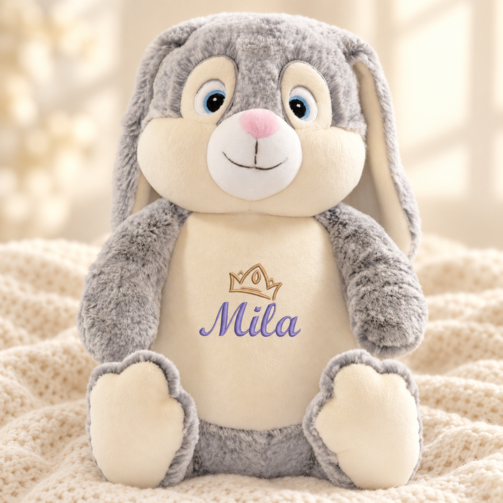 Personalisiertes Kuscheltier Baby Bunny mit Name – Beispiel Mila auf cremefarbener Decke
