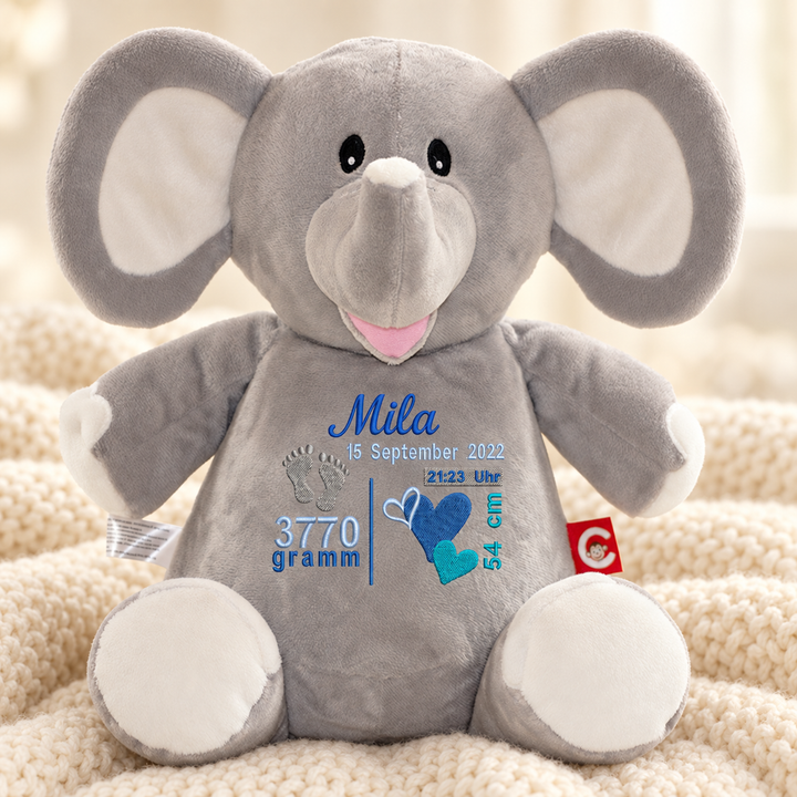 Personalisiertes Kuscheltier Grey Elephant mit Name &amp; Geburtsdaten – Beispiel Mila auf cremefarbener Decke